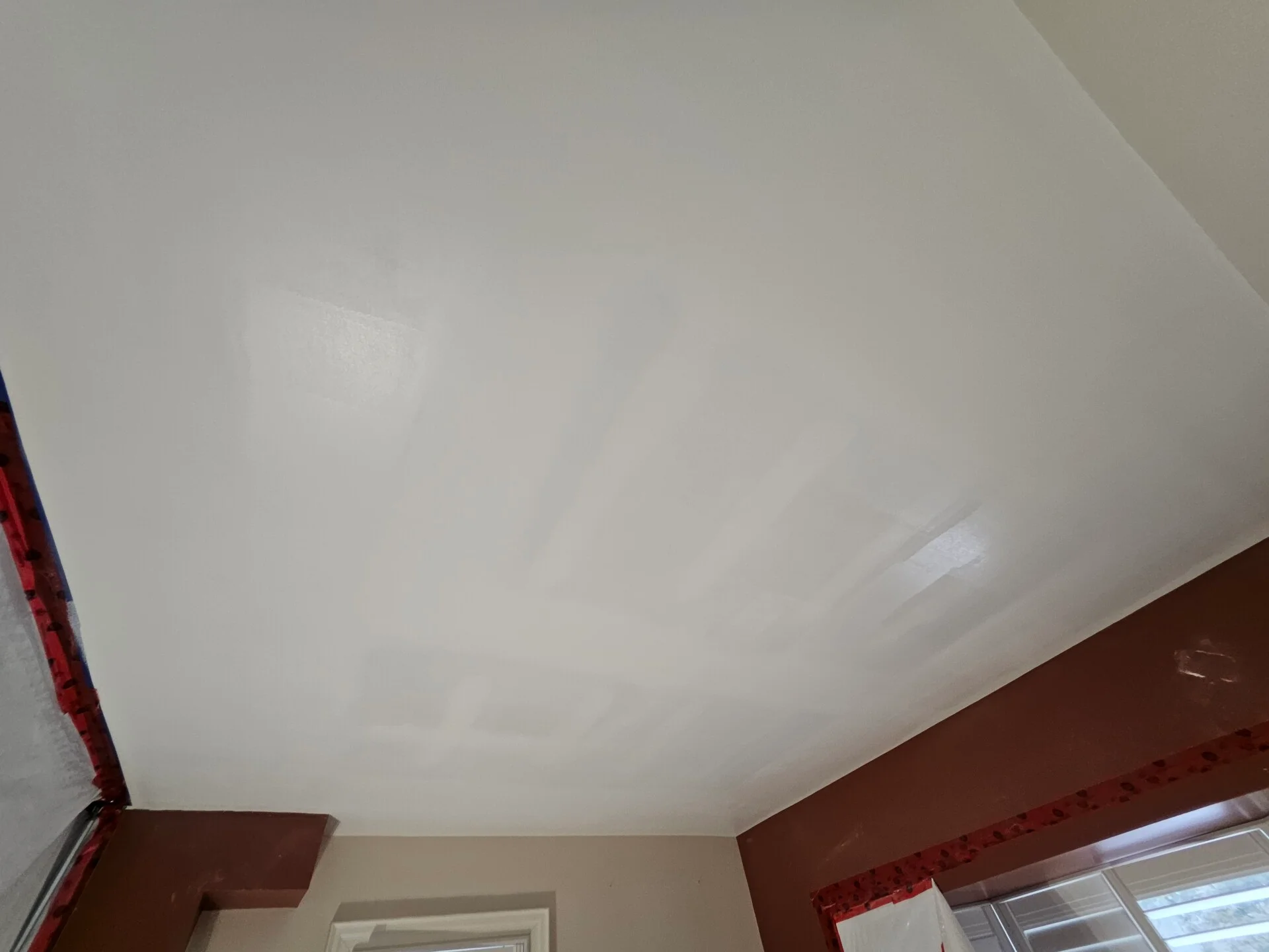 Joint compound applied across a boarded ceiling ahead of final finishing.